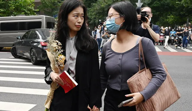 Zhou (izq.) camina junto a una simpatizante antes de asistir a su audiencia en el caso de acoso sexual contra el destacado presentador de televisión Zhu Jun - Pekín, 14 de setiembre.